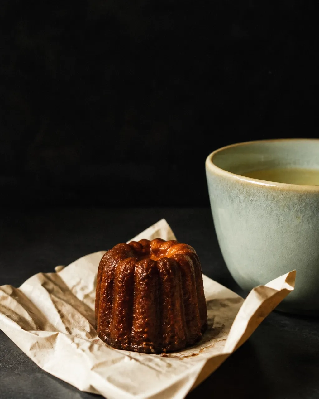 A warm editorial still life of a pastry and seafoam cup